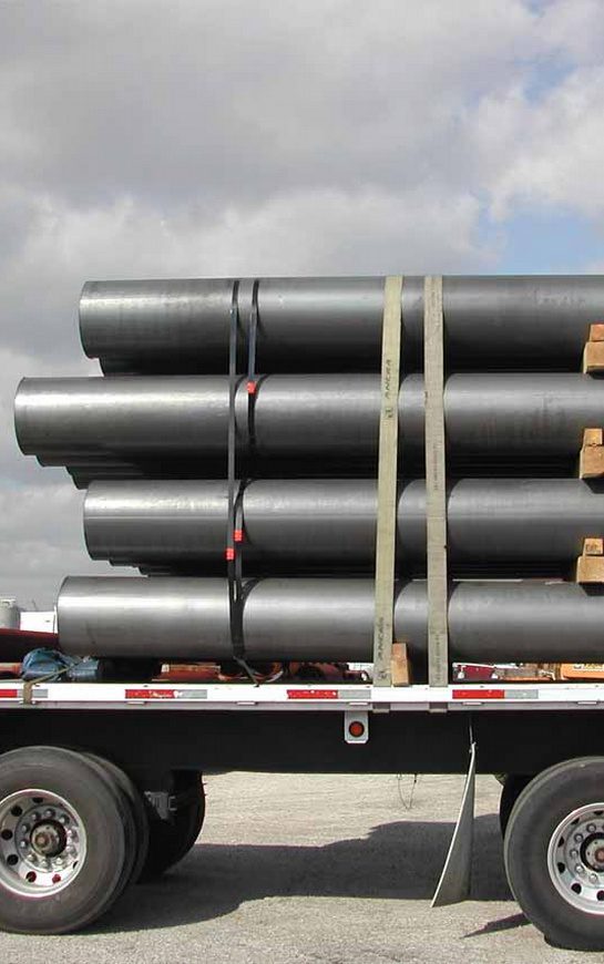 A truck with several pipes stacked on top of each other.