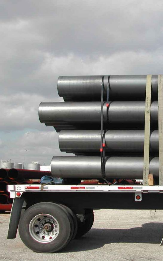 A truck with many pipes stacked on it