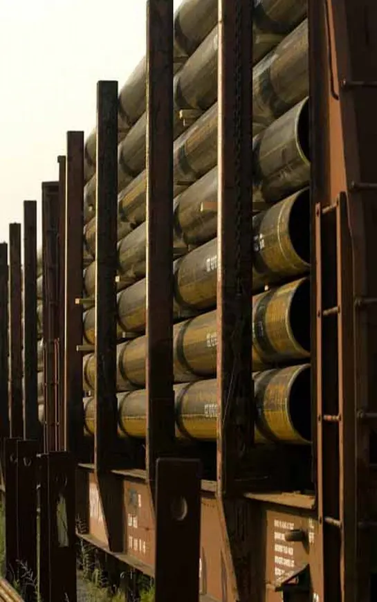 A bunch of barrels are stacked up in a warehouse.