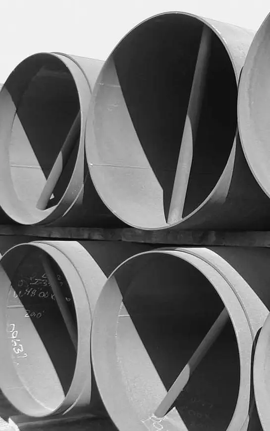 A black and white photo of pipes stacked on top of each other.