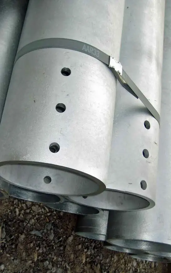 A close up of two metal cylinders with holes.