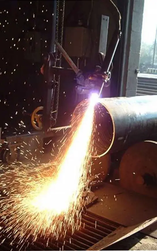 A metal pipe being cut with a plasma cutter.