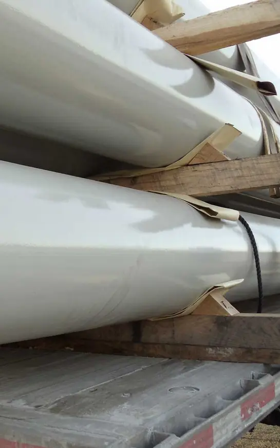 A close up of two pipes on wooden pallets